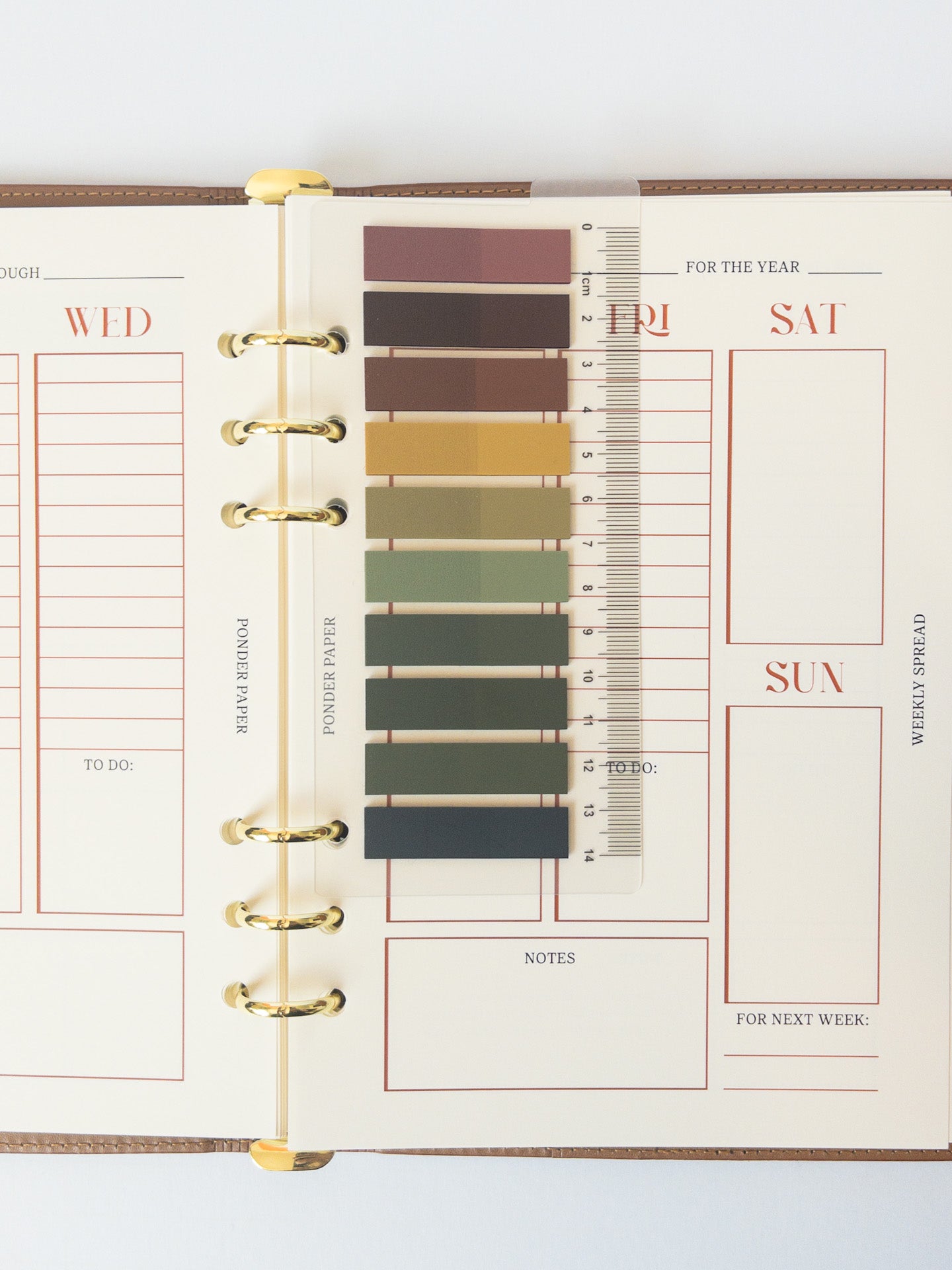 Clear Bookmark with Sticky Notes in front of Leather Binder