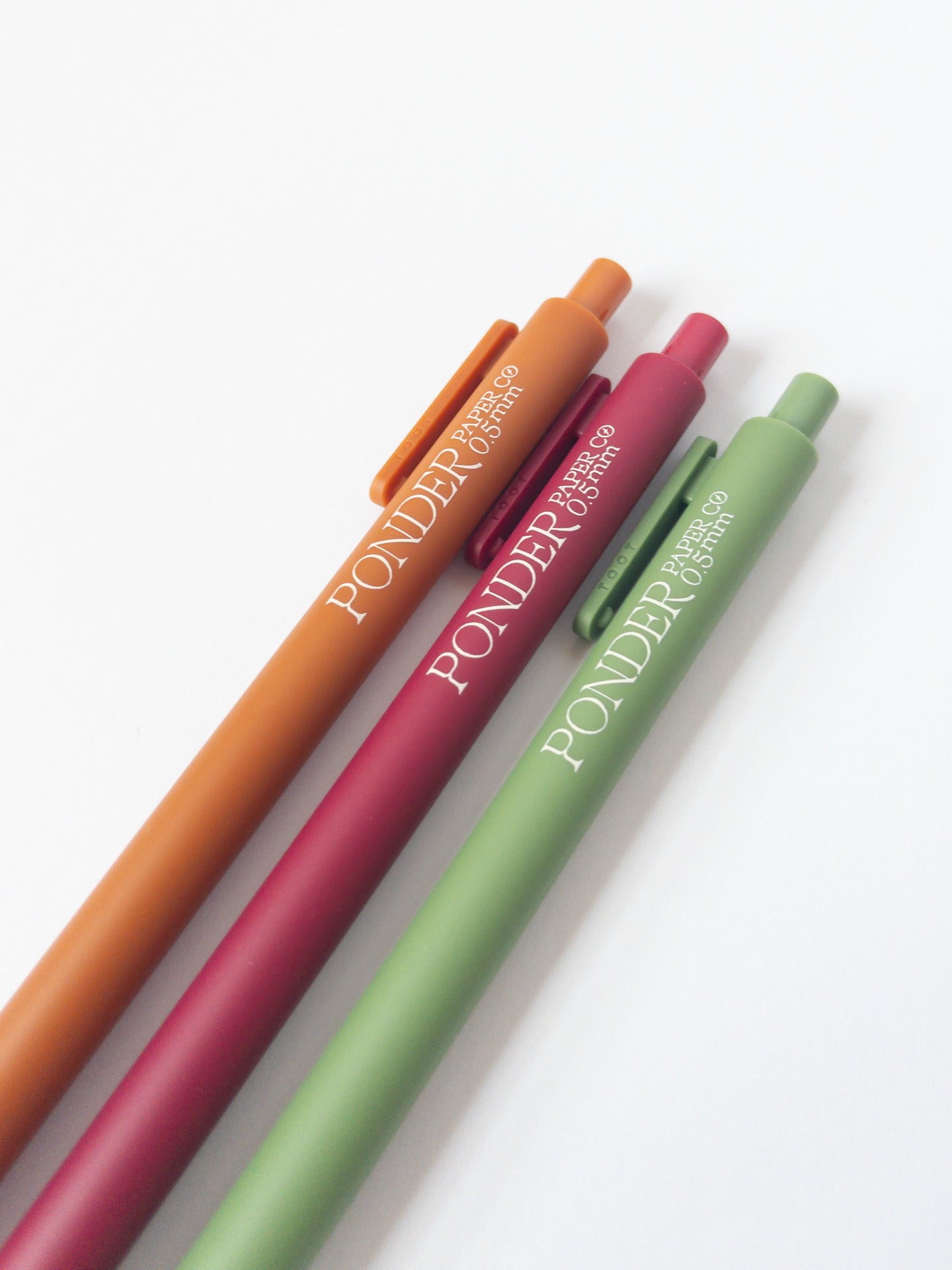 Orange, Magenta, and Olive Gel Pens at an angle
