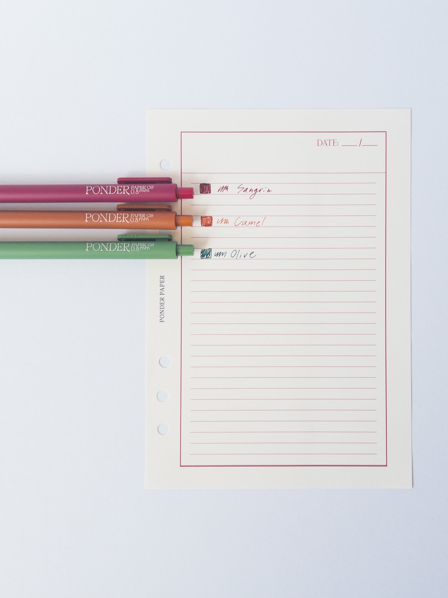 Orange, Magenta, and Olive Gel Pens on Weekly Planner Notepad